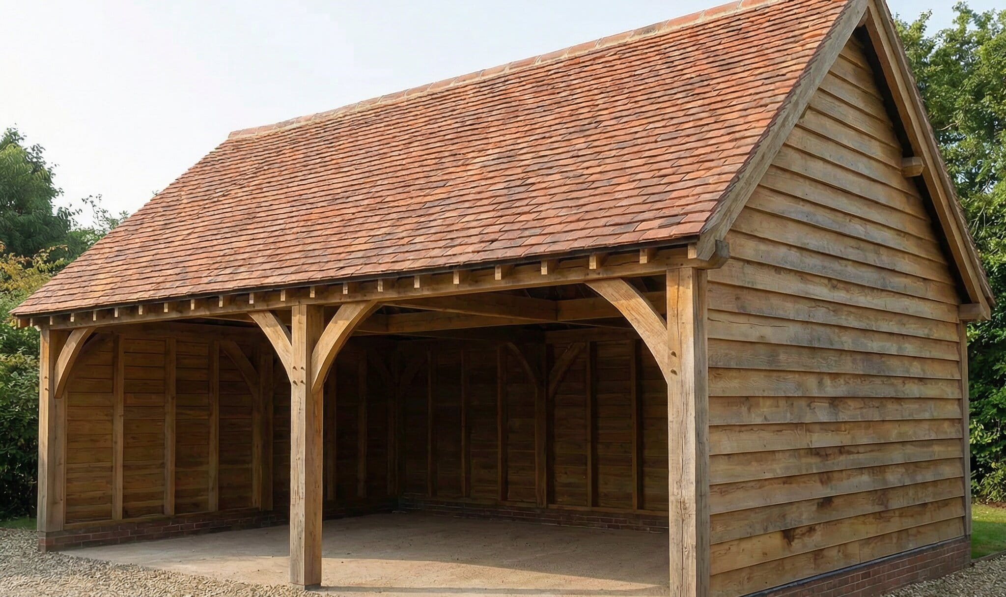 A classic two-bay oak framed garage with traditional timber cladding and a red clay tile roof, precision-engineered in Staffordshire.