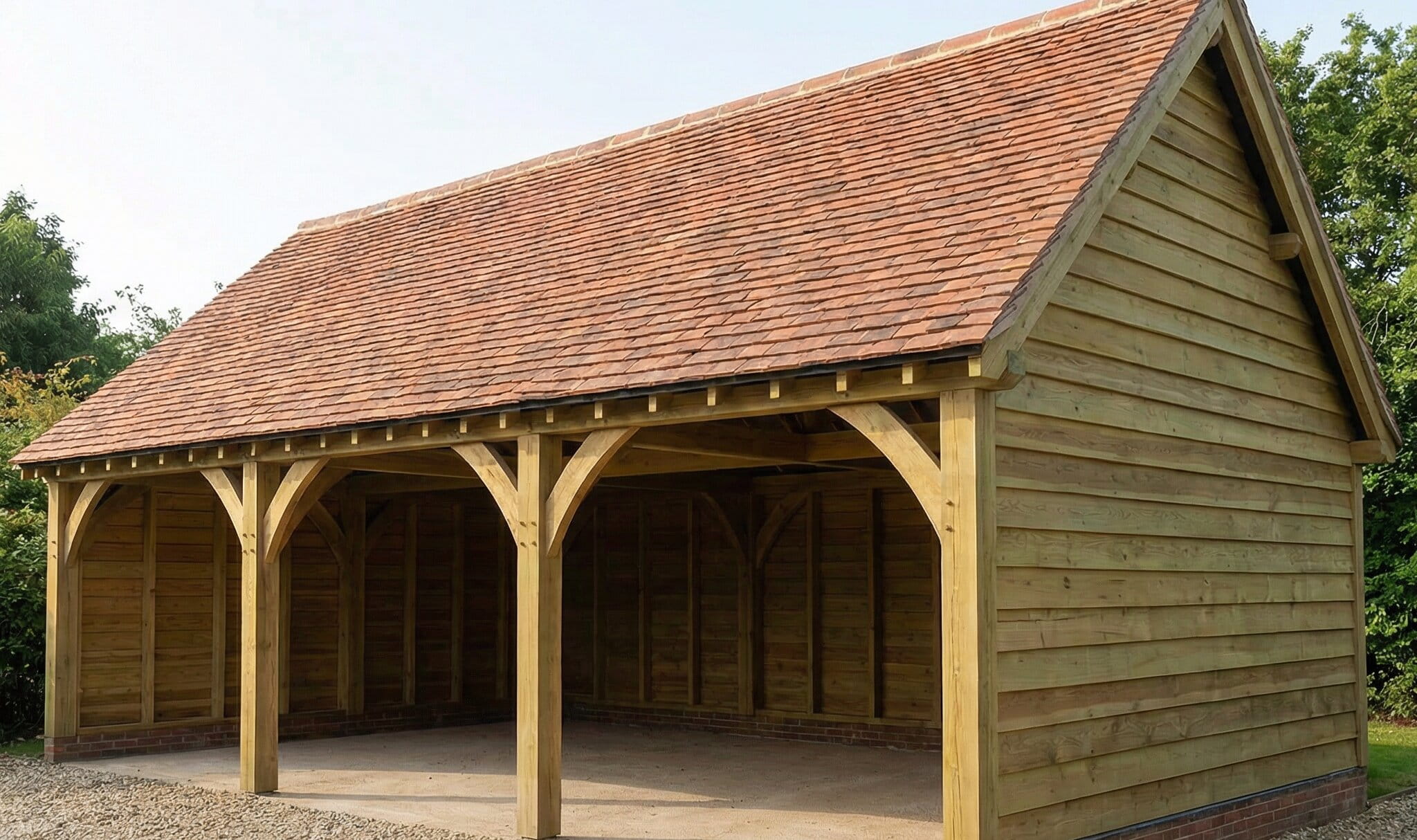 A large three-bay oak framed garage with traditional timber cladding and a red-tiled pitched roof, ideal for multiple vehicles or a workshop.
