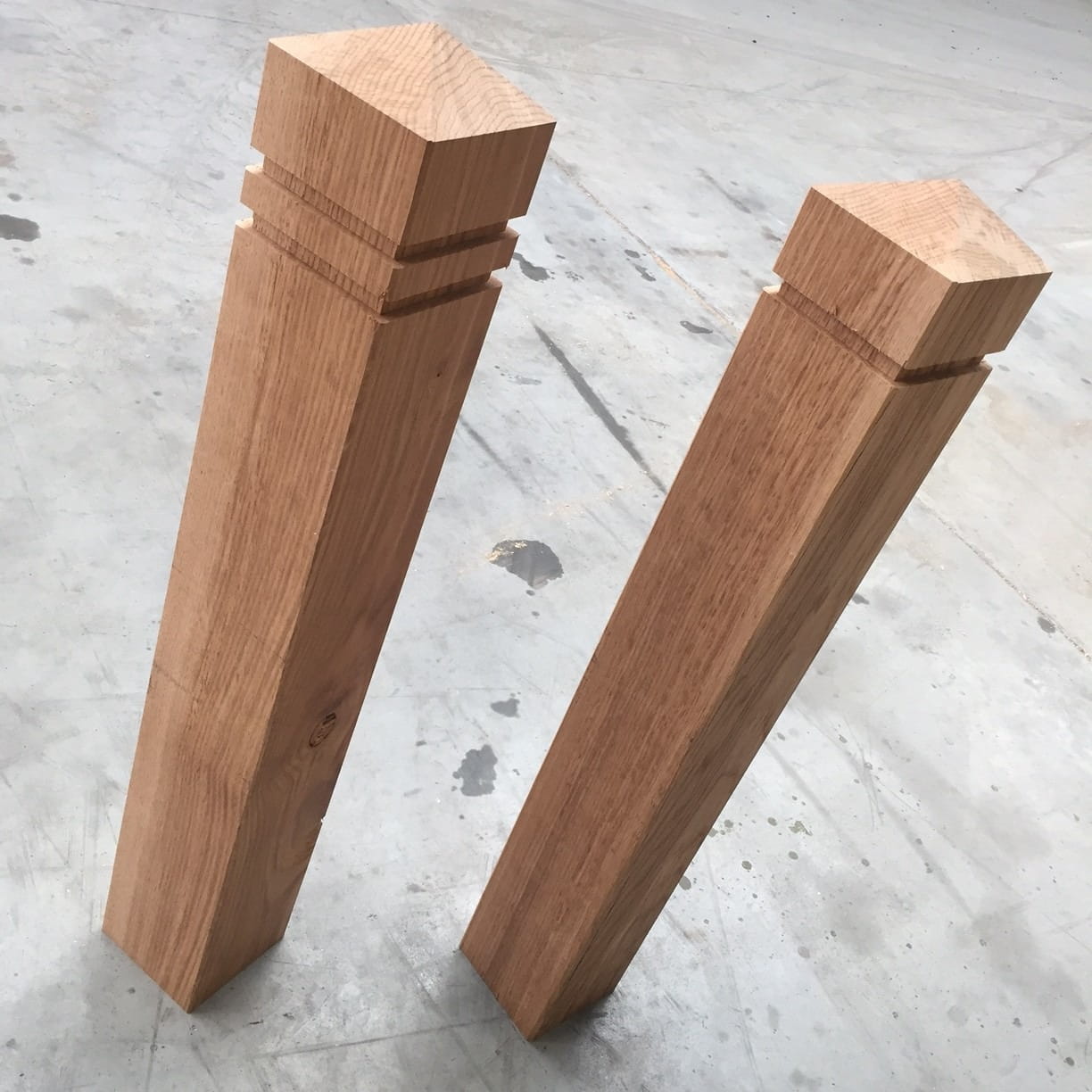 Two precision-machined oak timber posts with decorative chamfered tops and horizontal groove detailing.