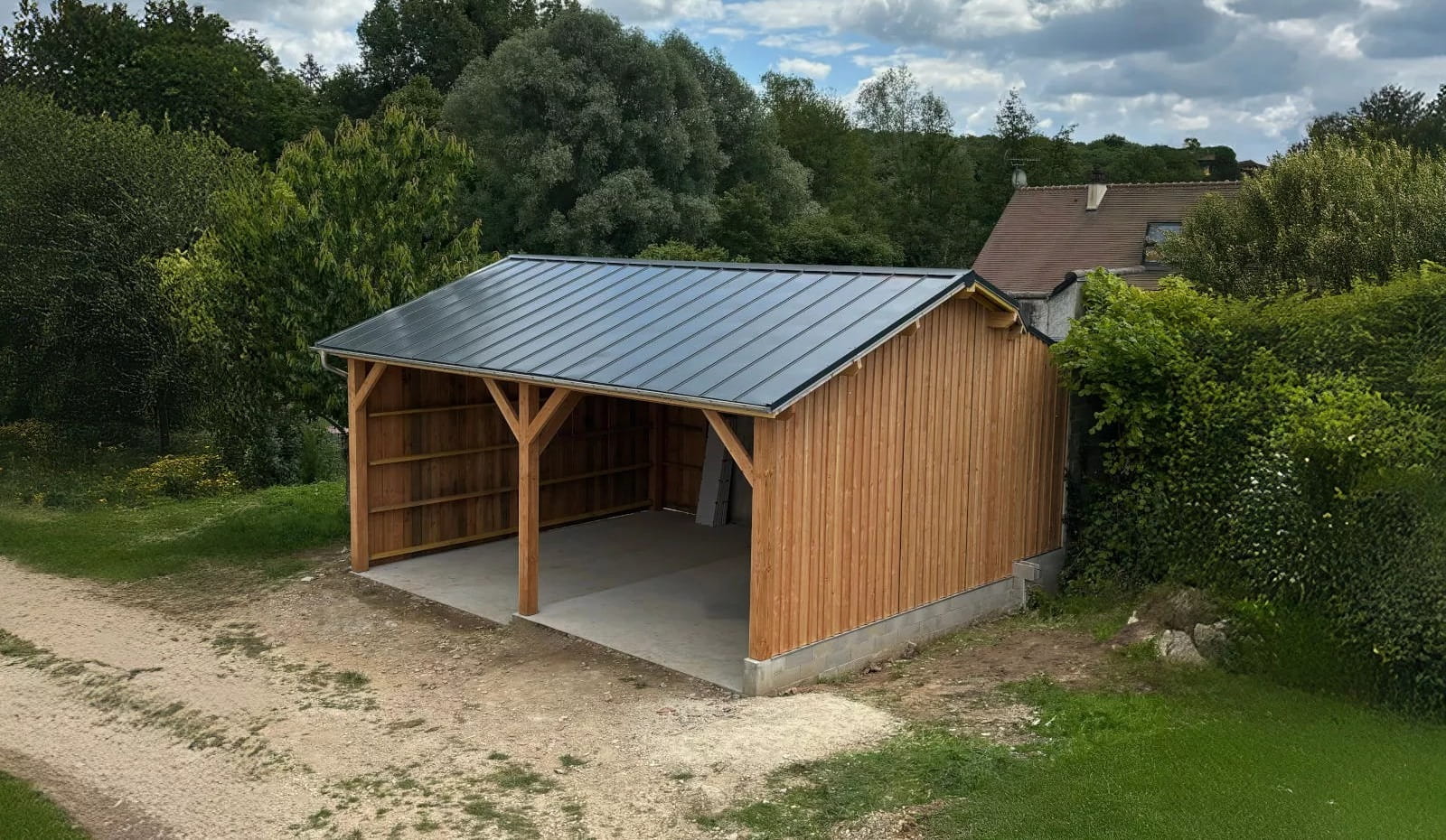 An outdoor timber frame carport or shed made of Douglas Fir with a dark metal roof, showcasing the wood's warm red-pink tones and straight grain.